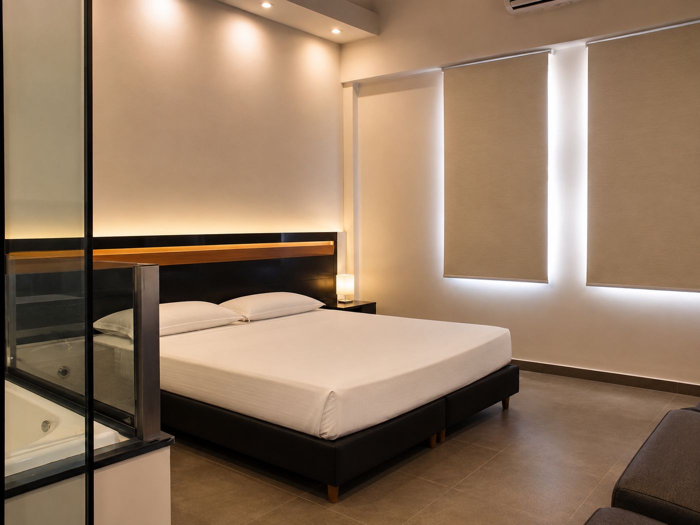 Categoría Suite con Hidro: cama king con hidromasaje detrás de un paño de vidrio.